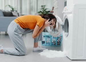 Woman checking leaking washing machine at home in London, calling for repair service