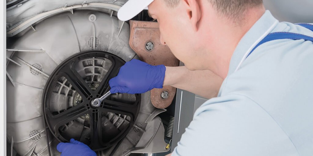 appliance engineer repairing washing machine drum issue
technician fixing washing machine belt and motor problem
washing machine drum repair service close up
engineer diagnosing washing machine not spinning problem